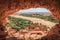 Popular point of view of the valley of the desolating river Onila through a hole in a wall of Ancient Kasbah in Ait-Ben