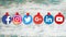 Popular round social media icons taped on old wood