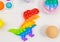 Popular silicone dinosaurs anti-stress pop it toys on white wooden background. Trendy reliever stress Sensory Fidget Toy. Funny