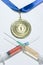 Popular steroids in two colorful syringes as a doping near a gold medal on a white background