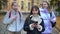 Popular teen schoolgirl walking with smartphone scrolling social media as friends talking smiling passing camera