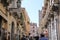 A populated narrow street in an Italian town, with tenement houses on both sides