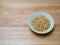 Porcelain bowl filled with pine nuts on chopping block