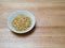 Porcelain bowl filled with pine nuts on chopping block