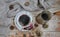 Porcelain cup of black coffee and coffeepot on the rustic background with winter decoration.