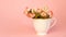 Porcelain cup full of flowers on pink background. Copy space, banner. Spring cozy home. Good morning concept.