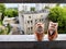 Porcelain figurines of couple of cats in men's and women's costumes on a high balcony against the backdrop of