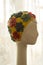 Porcelain head of mannequin with a retro swimming yellow hat with flowers