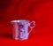 Porcelain pink cup of an unusual shape is made in the Czech Republic. A cup with a romantic pattern on a red background