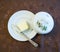 Porcelain plate with cover and silver knife with butter on a decorated cover - top view