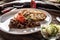 Porcelain plate full of deer venison goulash stew served with dumpling and fresh salad as an appetizer. Food is surrounded by