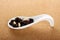 Porcelain spoon with raisins and pine nuts