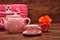 A porcelain spotted tea set with a pink basket and an orange rose