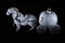 Porcelain toy carriage with horse. Ceramic`s pumpkin coach,  black background, light painting photo in dark