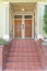 Porch with red tile doorsteps and three wooden front doors with transom windows at San Francisco, CA