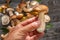 Porcini in male hand close up and fresh harvest of porcini mushrooms on table at the background