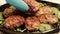 Pork, beef or chicken minced meat cutlets. The cook decorates the pan with the cooked food. Pan-fried meatballs
