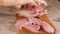 Pork is on the Board. Sliced pork meat. Take a piece of meat in your hand and throw it down. Cook`s hands were clad in