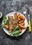 Pork chop with caramelized grilled apples and arugula salad on a dark background, top view