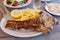 Pork chop with french fries portion in greek tavern.