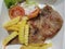 Pork chop steak, vegetable salad and french fries