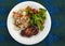 pork chops, rice and salad on a plate