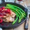 Pork cutlets with raspberry sauce and asparagus in iron cast pan, square