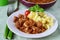 Pork fried with onions on a plate with mashed potato. Home cooking.