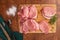 Pork loin chops on a wooden cutting board with some ingredients on wooden background