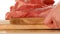 Pork meat. meat on a wooden cutting board.Hands put pieces of chopped meat on a board on a wooden table on a white