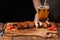 Pork ribs in barbecue sauce and honey baked tomatoes on the old wooden table. Meats and light beer on black background with copy s