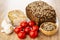 Pork salted lard with pepper, bread on cutting board, tomato, condiment, garlic on wooden table