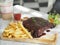 Pork Spareribs BBQ, Barbeque Pork Ribs with french fries vegetable salad, tomato sauce in a clear glass on wooden tray, food