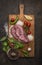 Pork steak on a cutting board with mushrooms and onions mushrooms and garlic tomato lemon and pepper on wooden rustic background