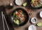 Pork, vegetables, rice stir fry. On a wooden table, top view.