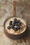 Porridge with Blueberries in Copper Saucepan on Weathered Stainless Steel Surface