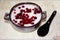 Porridge with cowberry in a ceramic bowl on a plastic napkin.