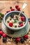 Porridge with milk , berries in rustic bowl on wooden background