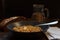 Porridge from spelt in a grey plate with a piece of butter, on a dark background horizontally