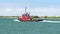 PORT ARANSAS, TX - 27 JAN 2020: Lone Star State is a red working tug boat sailing on the ship channel between the Gulf of Mexico