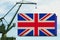 Port crane holds a container with the flag of Great Britain, the concept of shipping from a country around the world by sea,