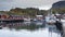 Port of the fishing town of Nusfjord, Norway, Lofoten islands, golden autumn surrounded by colorful mountains and blue water