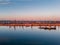 Port river cranes loading ships on barges delivery, sunset