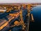 Port river cranes loading ships on barges delivery, sunset