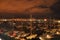 Port San Rocco night scene, sailing boats moored and Trieste city lights in background