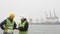 Port workers in helmets are looking at documents. sea port