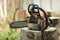 Portable chainsaw machine with sawdust line on wood stump banner on blur background. Heavy duty wood cutting equipment