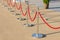 Portable fencing shiny metallic barrier outside. Red carpet safety rope