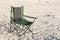 A portable foldable solar panel hangs on a travel chair. Tourist camping on the seashore