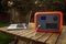 Portable power station solar electricity generator outdoors with laptop plugged in charging.